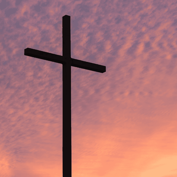 Silhouette of a cross against a colorful sunset sky.